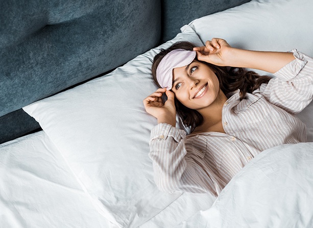 Woman waking up in bed with a smile