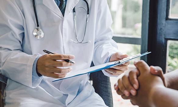 Doctor taking notes during consultation with patient