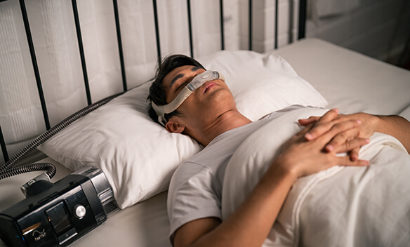 Man sleeping with oral appliance and CPAP nasal mask